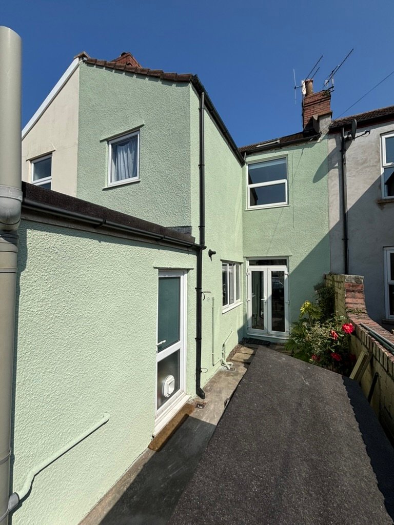 Cork spray finished exterior wall project in pale green